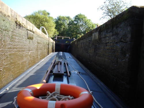 The view from the driver's position at the back of the boat sitting in a lock where the water level has been lowered.